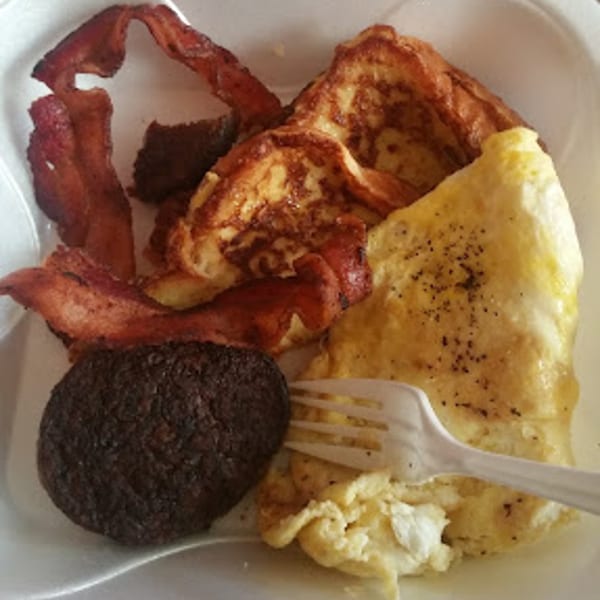 Sammy's Touch breakfast with French toast, bacon, scrambled eggs, and a sausage patty.